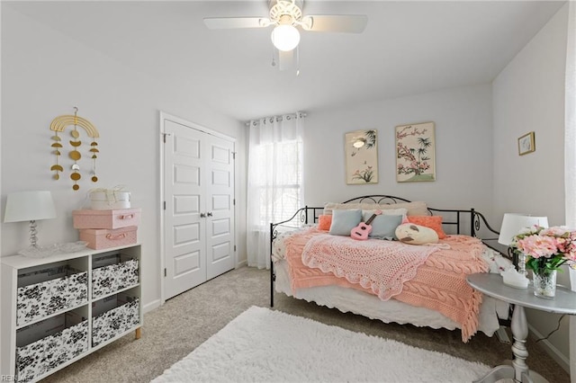 carpeted bedroom featuring baseboards and a ceiling fan