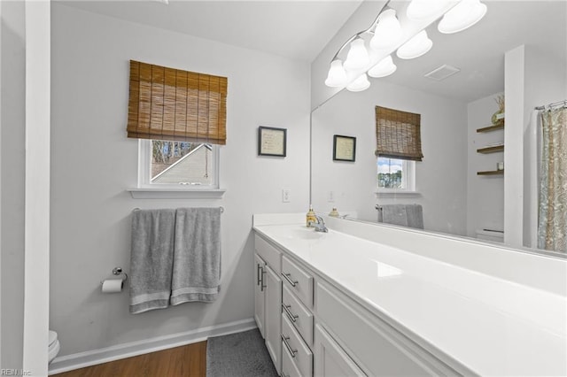 full bathroom featuring visible vents, baseboards, toilet, an inviting chandelier, and vanity