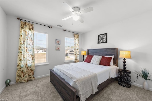 carpeted bedroom with a ceiling fan, baseboards, and visible vents