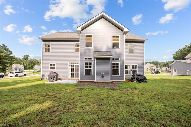 rear view of house featuring a yard and a patio