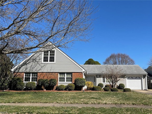 view of front facade with brick siding, an attached garage, concrete driveway, and a front yard