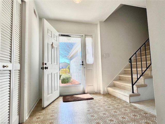 entryway featuring tile patterned floors, baseboards, and stairs