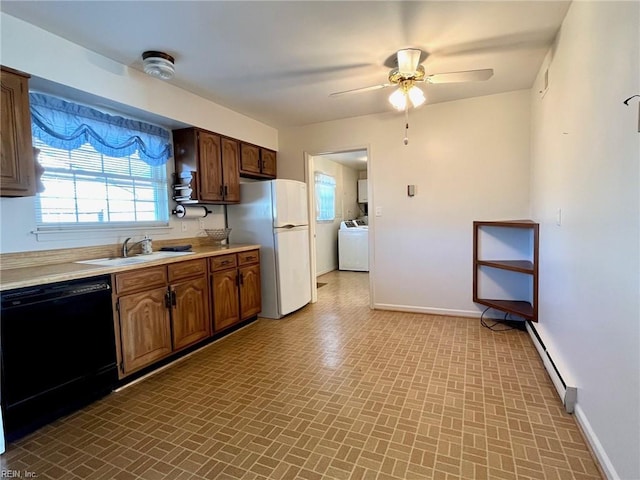 kitchen featuring a baseboard heating unit, washer / clothes dryer, black dishwasher, freestanding refrigerator, and baseboards