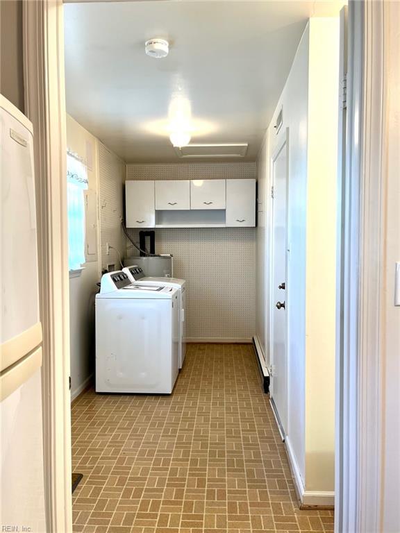 washroom with independent washer and dryer, laundry area, brick floor, and water heater