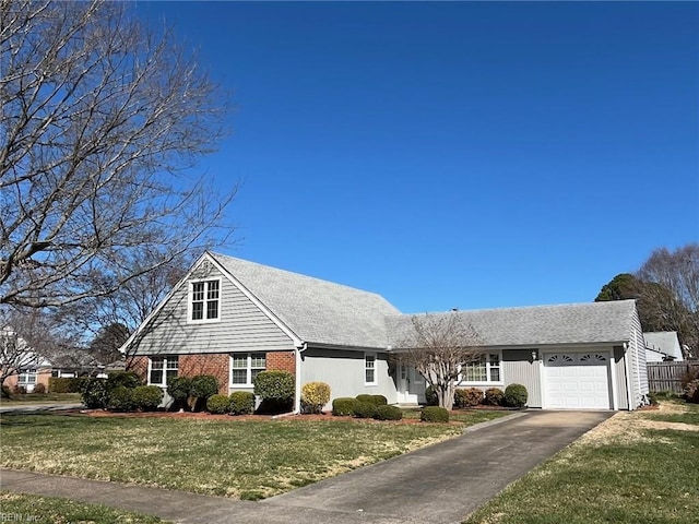 view of front of home featuring a front yard, an attached garage, brick siding, and driveway