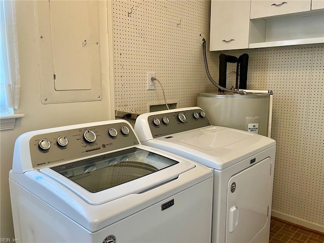 clothes washing area featuring brick floor, cabinet space, separate washer and dryer, and water heater