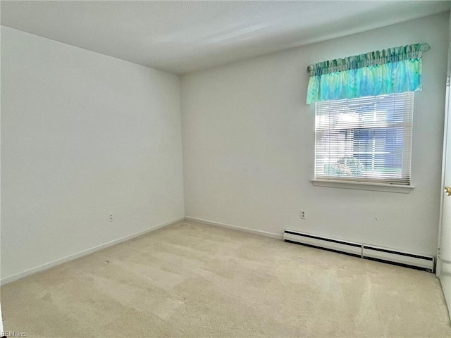 carpeted spare room featuring a baseboard heating unit and baseboards