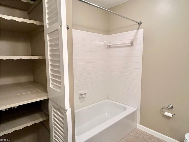 full bathroom featuring tile patterned flooring, washtub / shower combination, and baseboards