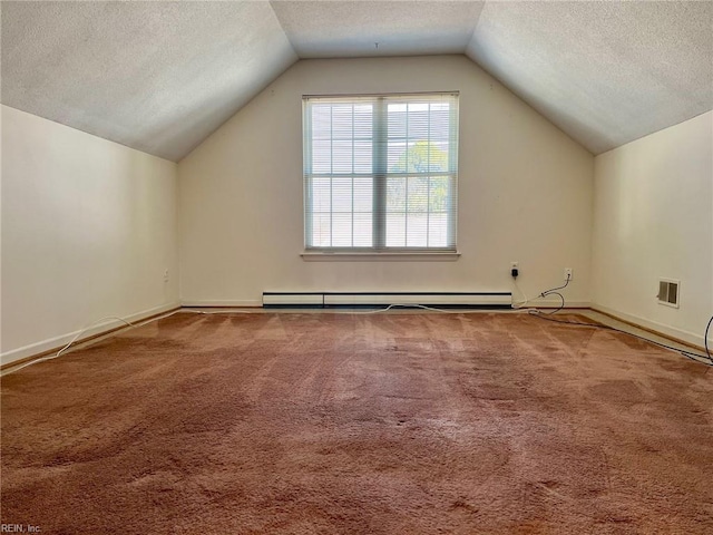 additional living space with a baseboard heating unit, a textured ceiling, visible vents, and carpet flooring