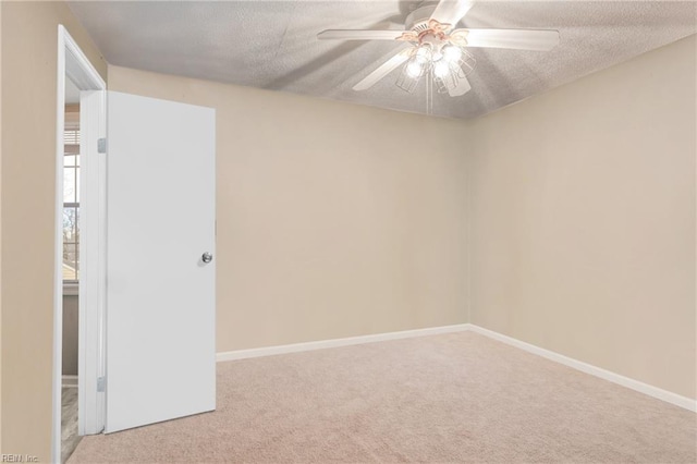 unfurnished room featuring a ceiling fan, carpet, baseboards, and a textured ceiling