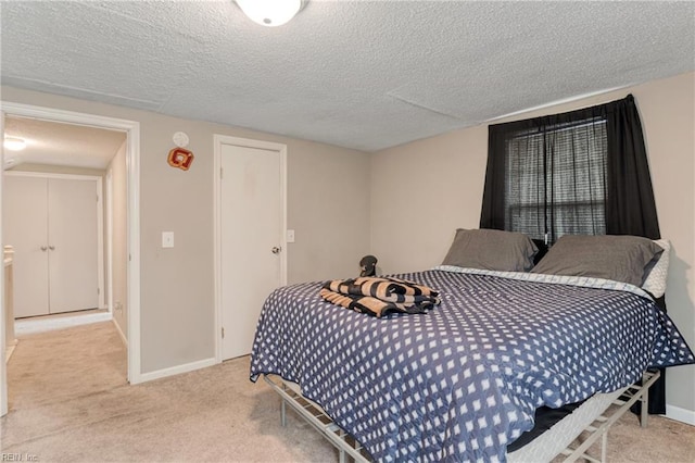 carpeted bedroom with baseboards and a textured ceiling