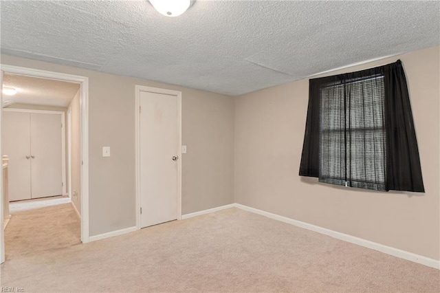 carpeted spare room with baseboards and a textured ceiling