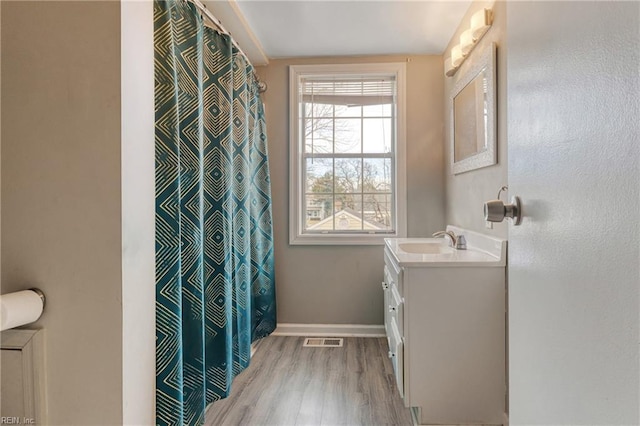 bathroom with visible vents, baseboards, a shower with shower curtain, wood finished floors, and vanity