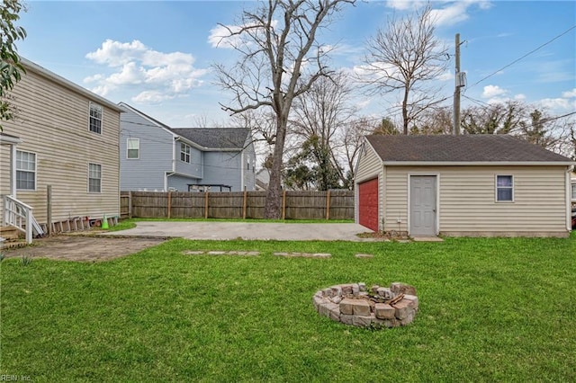 view of yard with an outbuilding, a fire pit, a patio, and fence