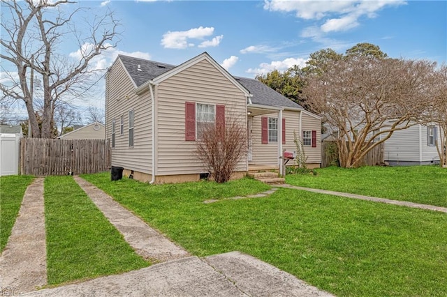 bungalow featuring a front lawn, fence, and roof with shingles