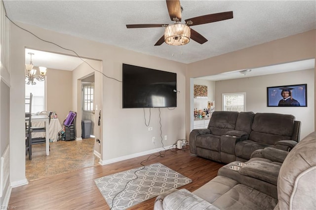 living room with wood finished floors, a wealth of natural light, and a textured ceiling