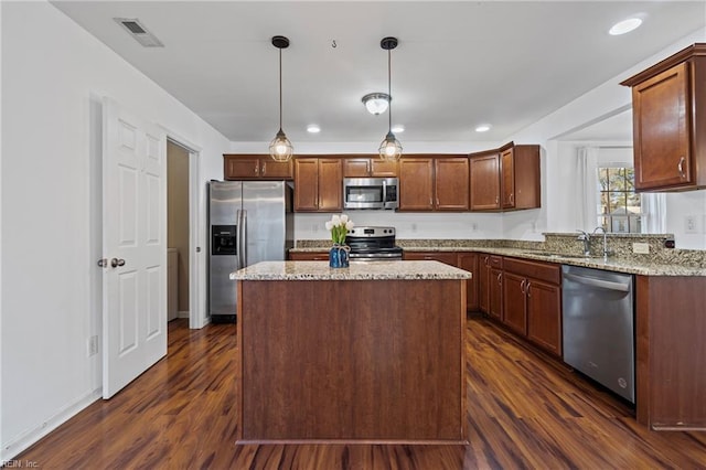 kitchen featuring visible vents, dark wood-type flooring, a sink, a kitchen island, and appliances with stainless steel finishes