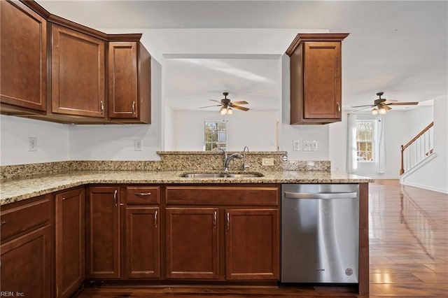 kitchen with dishwasher, a ceiling fan, light stone countertops, and a sink