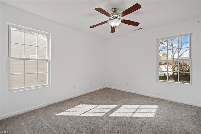 empty room with a ceiling fan, carpet flooring, baseboards, and visible vents