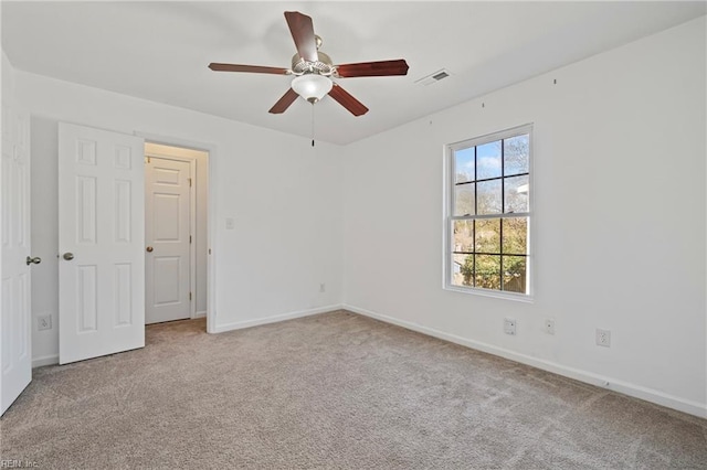 unfurnished room with a ceiling fan, carpet flooring, baseboards, and visible vents