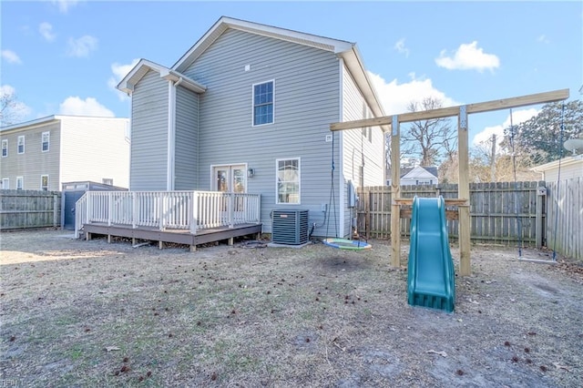 rear view of house with cooling unit, a fenced backyard, and a deck