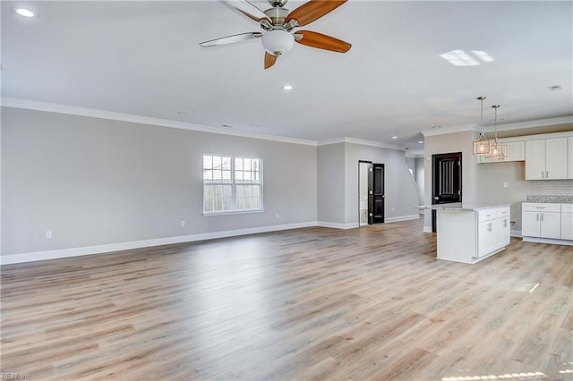 unfurnished living room featuring a ceiling fan, recessed lighting, light wood-style floors, crown molding, and baseboards