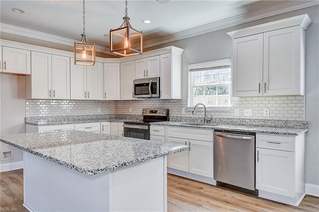 kitchen with appliances with stainless steel finishes, light wood-type flooring, crown molding, and a sink