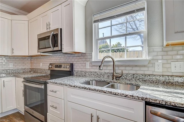 kitchen featuring white cabinets, stainless steel appliances, and a sink