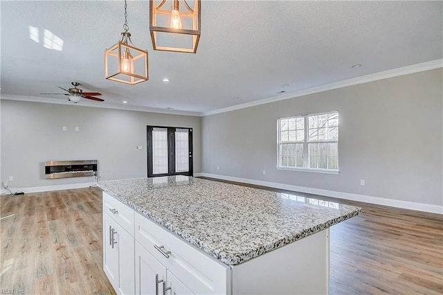 kitchen with light wood finished floors, open floor plan, and crown molding