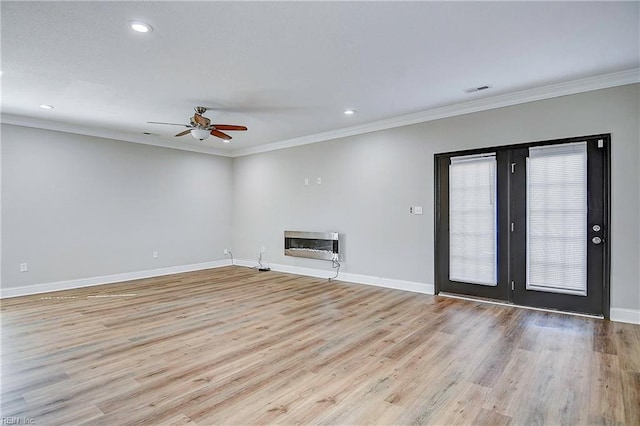 unfurnished living room with light wood-style flooring, baseboards, and a glass covered fireplace