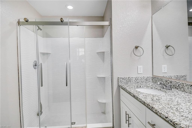 full bath with vanity and a shower stall