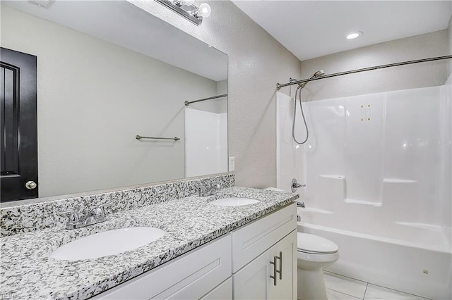 bathroom featuring a sink, washtub / shower combination, toilet, and double vanity