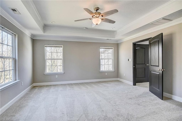 unfurnished bedroom with light carpet, visible vents, and a tray ceiling