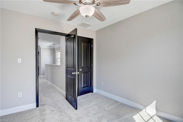 unfurnished bedroom with carpet, baseboards, visible vents, and a ceiling fan