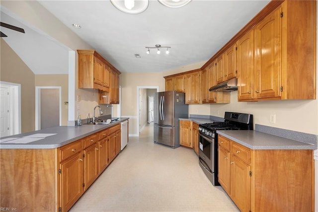 kitchen featuring under cabinet range hood, light floors, brown cabinets, stainless steel appliances, and a sink