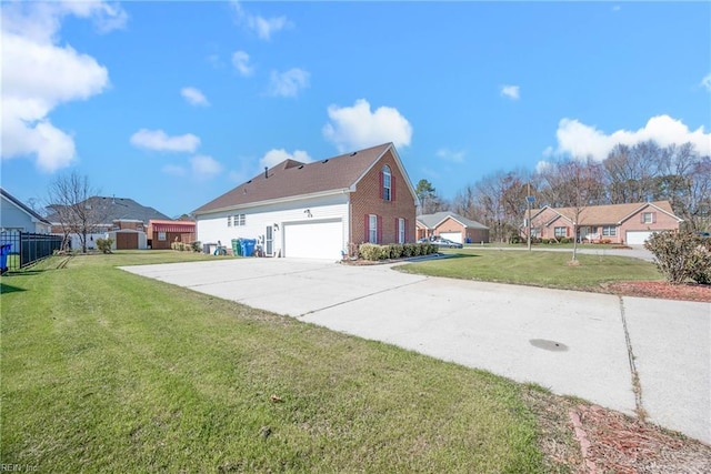 view of side of home featuring fence, driveway, a yard, brick siding, and a residential view