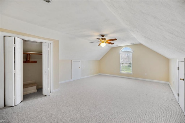 additional living space featuring carpet flooring, a textured ceiling, baseboards, and lofted ceiling