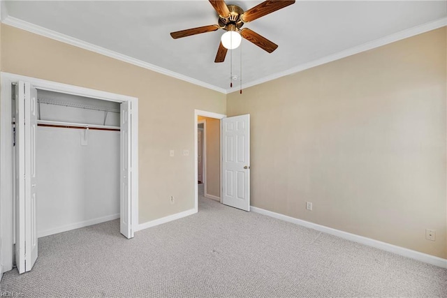 unfurnished bedroom with crown molding, carpet flooring, baseboards, and a closet