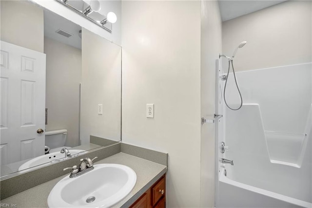 bathroom with visible vents, toilet, shower / washtub combination, and vanity