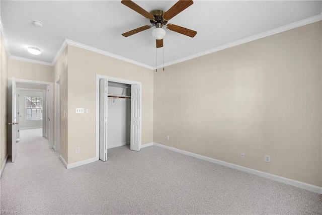 unfurnished bedroom with light carpet, ornamental molding, a ceiling fan, a closet, and baseboards