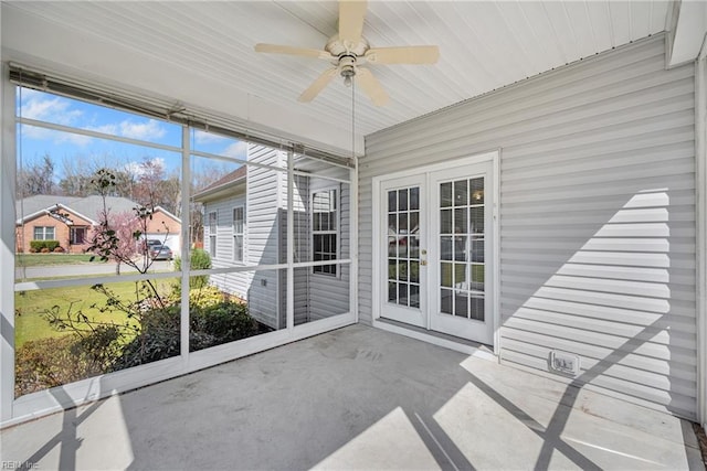 unfurnished sunroom with ceiling fan