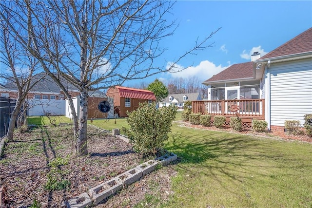 view of yard featuring an outbuilding, a fenced backyard, and a sunroom