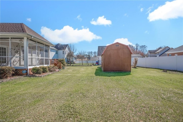 view of yard with an outdoor structure, a fenced backyard, a shed, and a sunroom