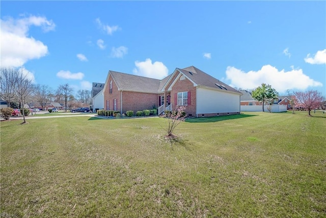 view of home's exterior featuring crawl space, a lawn, and brick siding