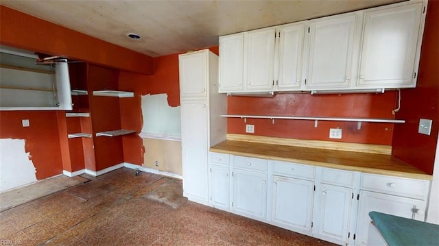 kitchen with white cabinetry, open shelves, and baseboards