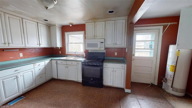 kitchen featuring white microwave, water heater, a sink, black range with gas stovetop, and white cabinetry