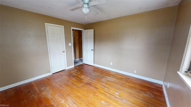 unfurnished bedroom with a ceiling fan, wood finished floors, and baseboards