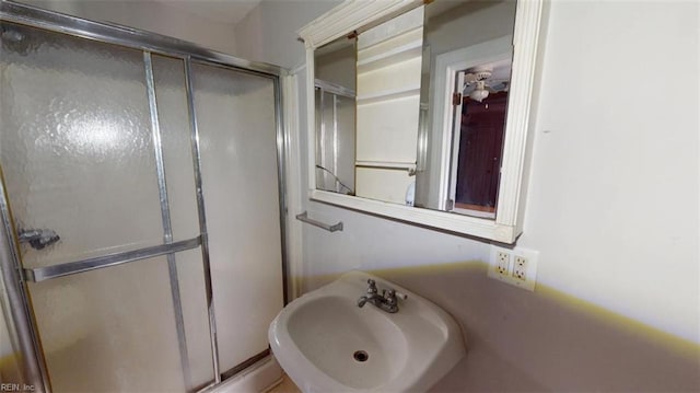 full bathroom featuring a shower stall and a sink