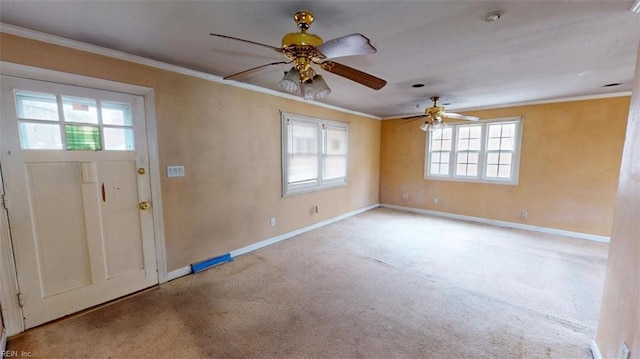 foyer entrance featuring baseboards, a ceiling fan, crown molding, and carpet