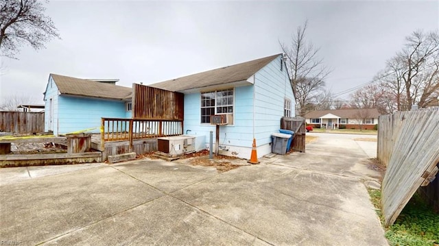 view of front of home with concrete driveway and fence